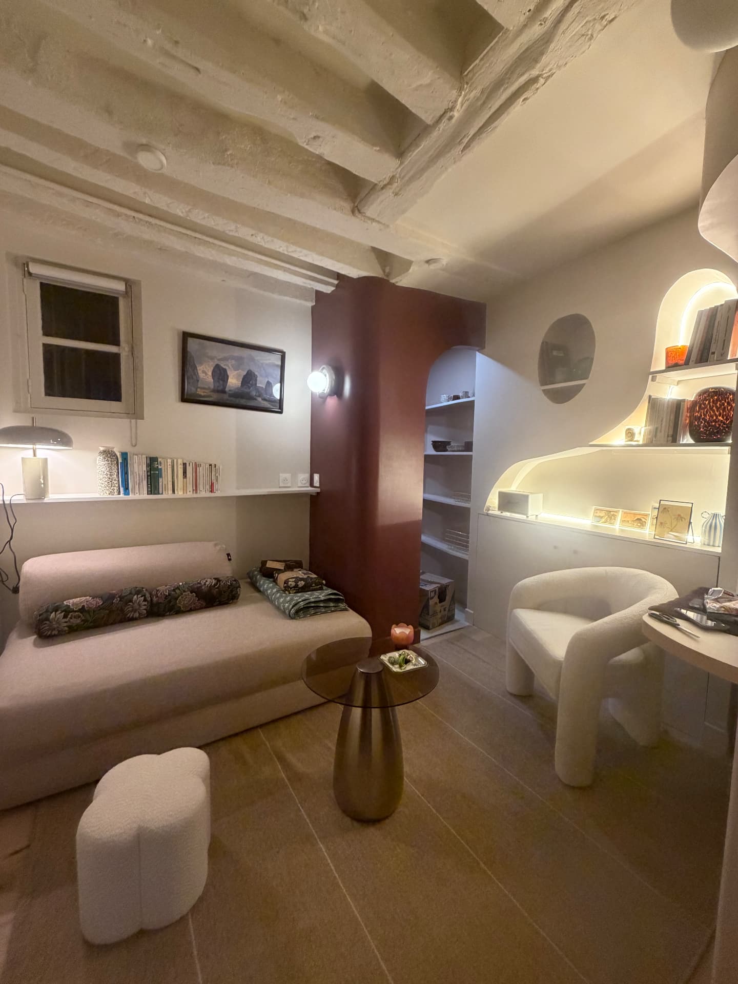 Le cabinet : canapé, fauteuil et bibliothèque sous les poutres apparentes, Paris 6e